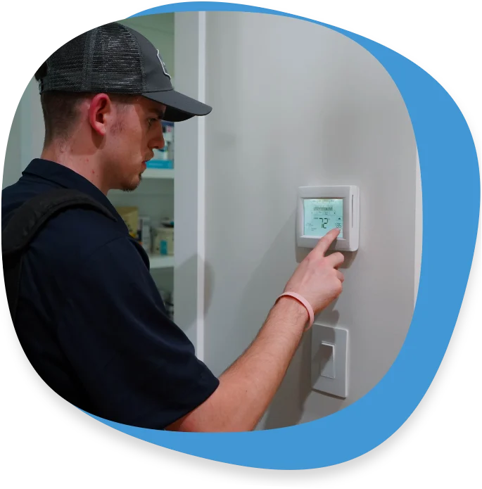 Technician adjusting a smart thermostat